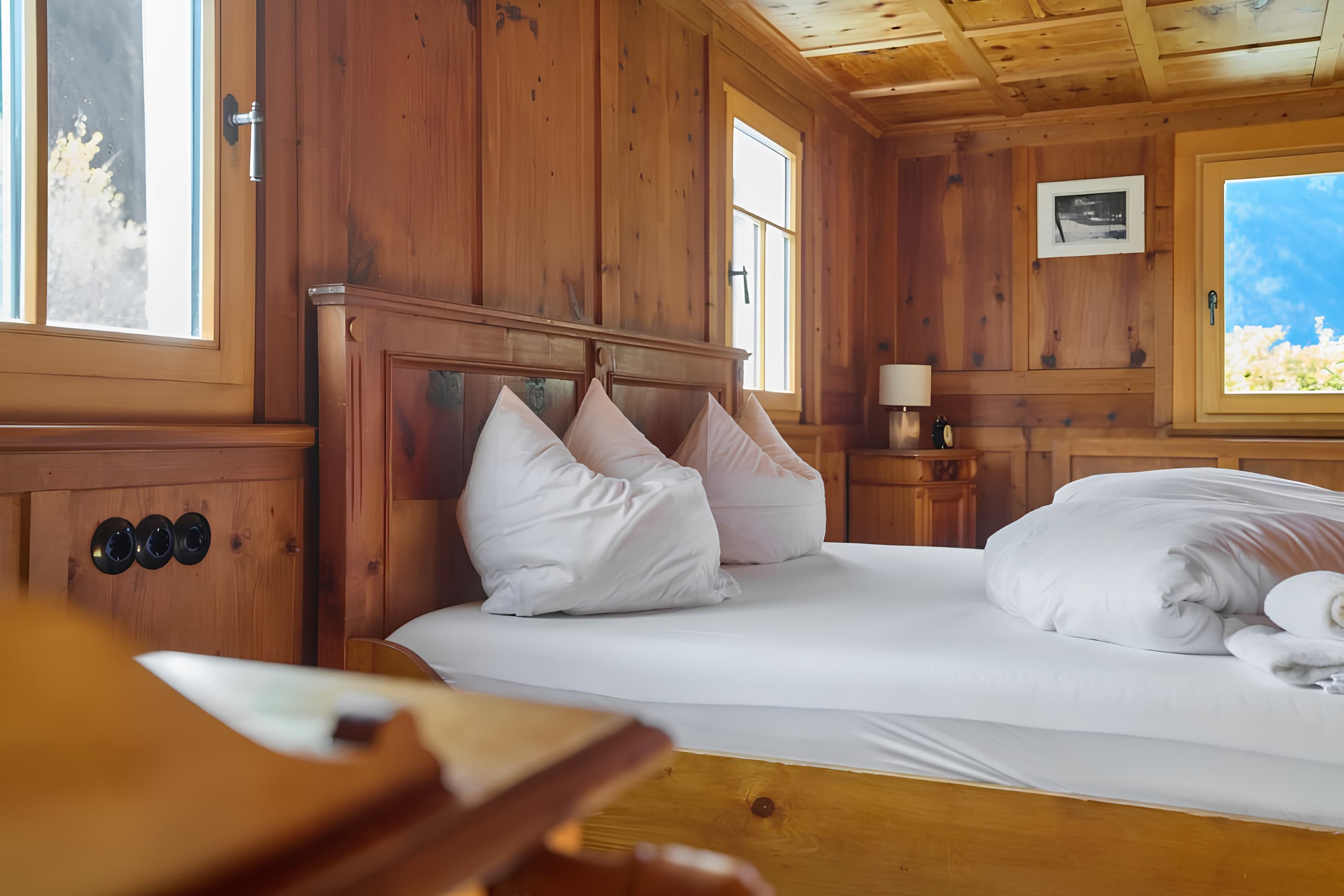 Quarto com paredes em madeira e roupa de cama branca — Villa Ulrich, Montafon