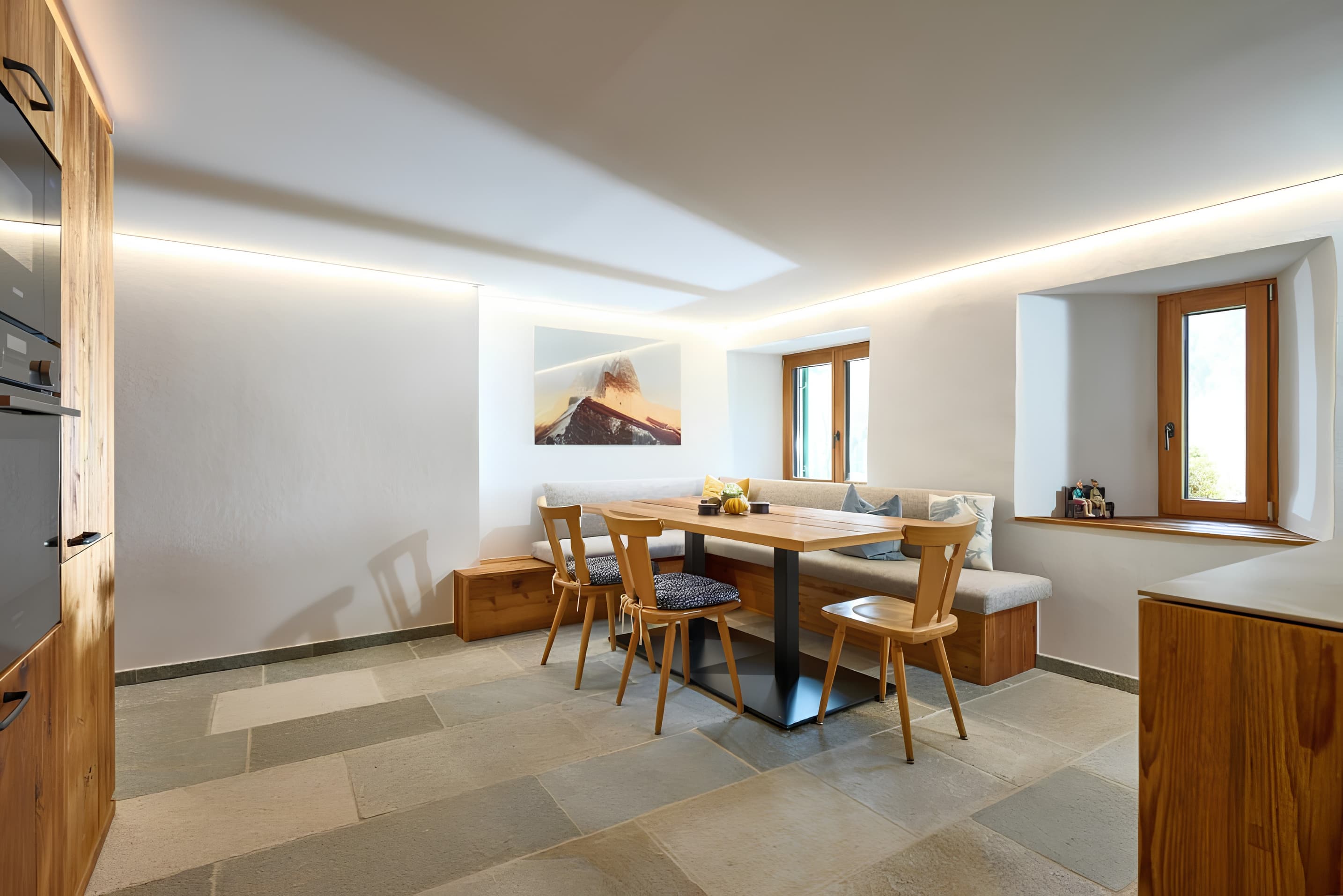 Sala de jantar com mesa em madeira e piso em pedra — Villa Ulrich, Montafon